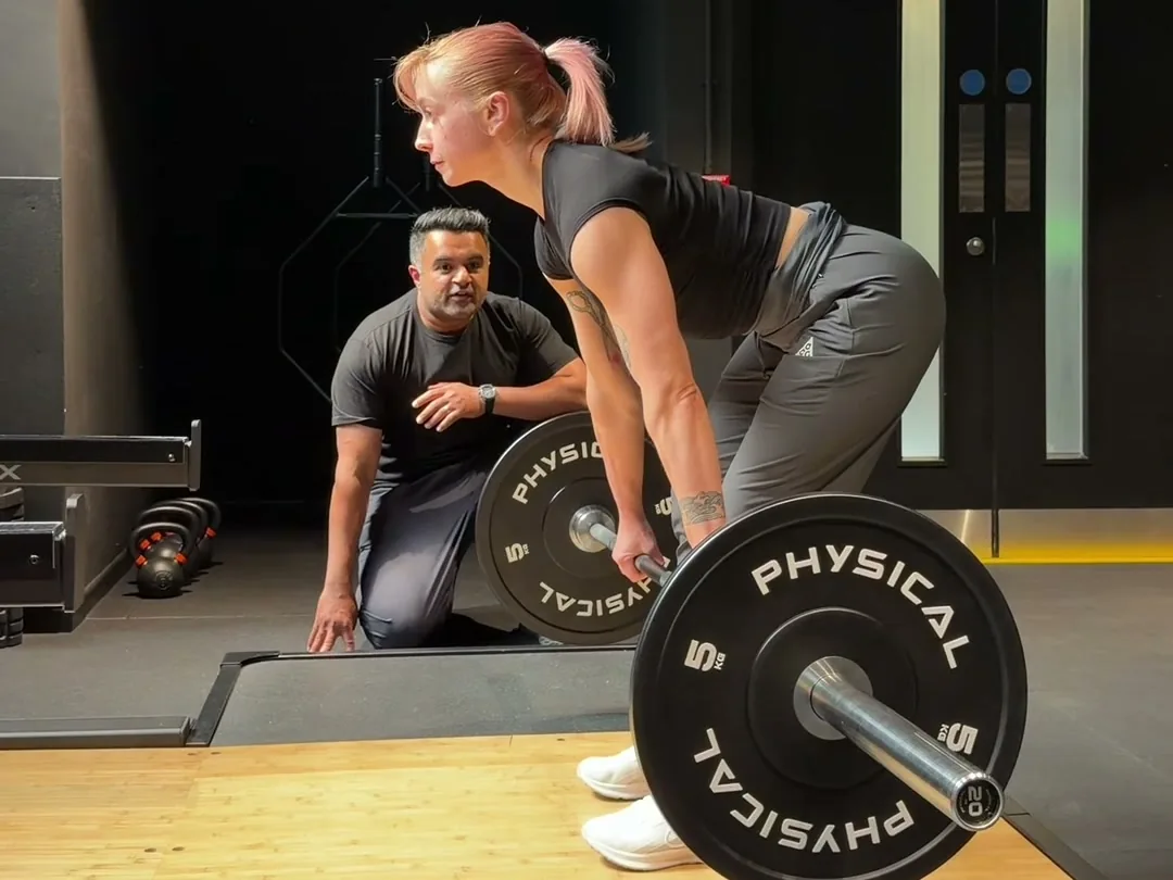 Khuram coaching an athlete through a strength exercise in the performance gym at Full Motion Physio Manchester